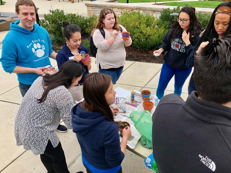Students for sustainability paint clay pots at event